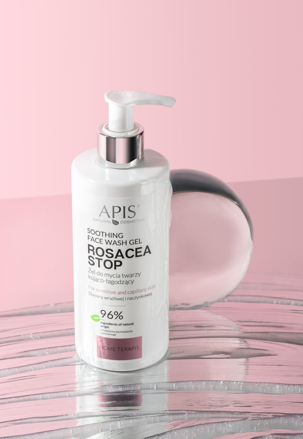 APIS Soothing Face Wash Gel Rosacea Stop in a white pump bottle with a silver collar, set against a pink background with a pink reflective surface.