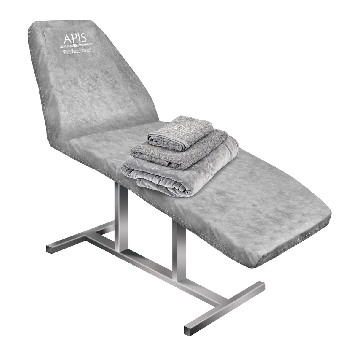 Gray massage table with folded towels on a white background, featuring the &