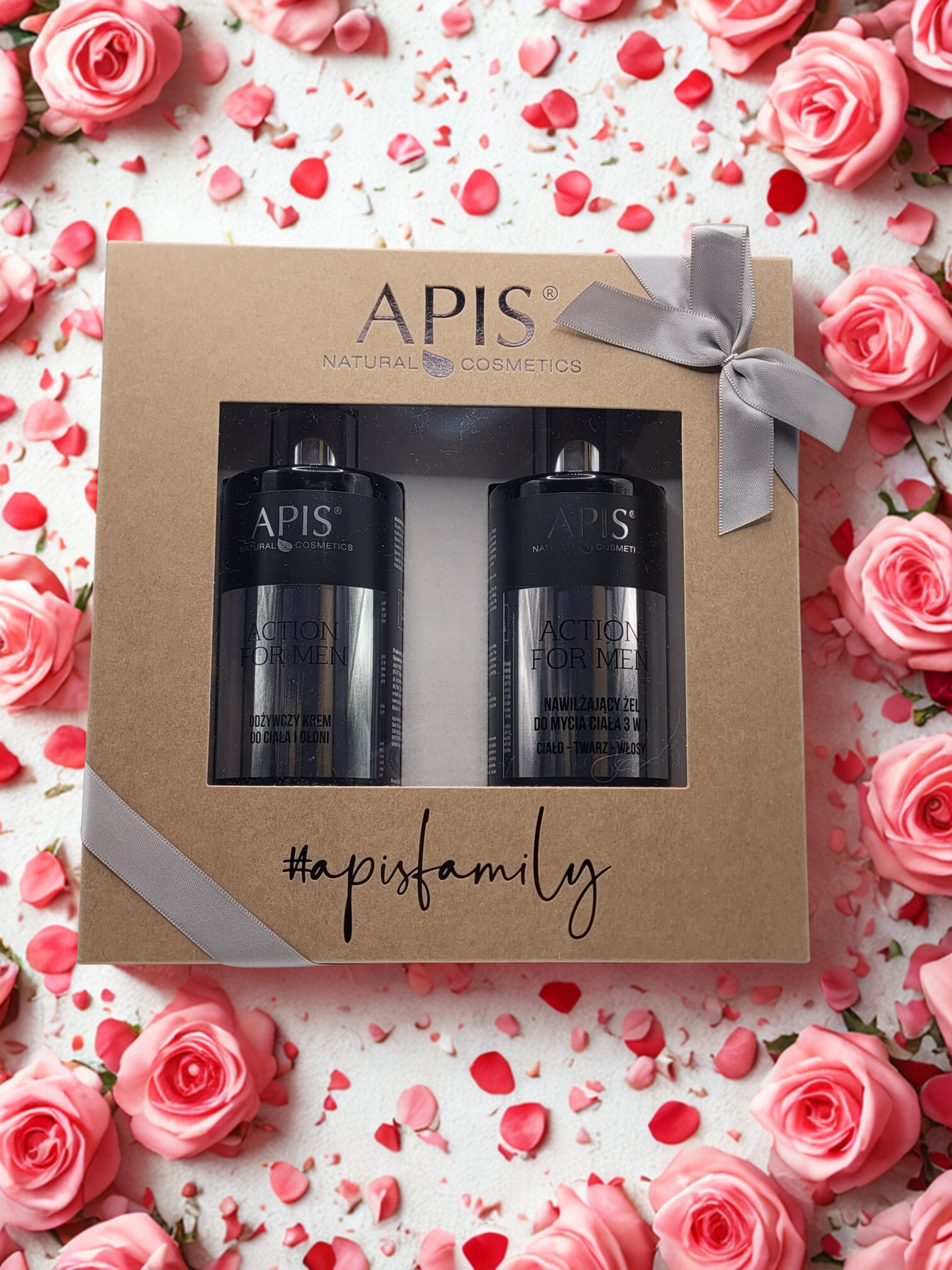 APIS cosmetic set in a gift box surrounded by pink roses and rose petals.