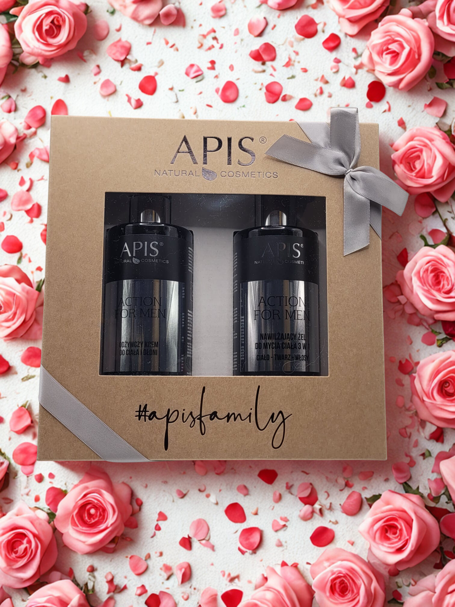APIS cosmetic set in a gift box surrounded by pink roses and rose petals.