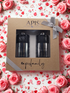 APIS cosmetic set in a gift box surrounded by pink roses and rose petals.