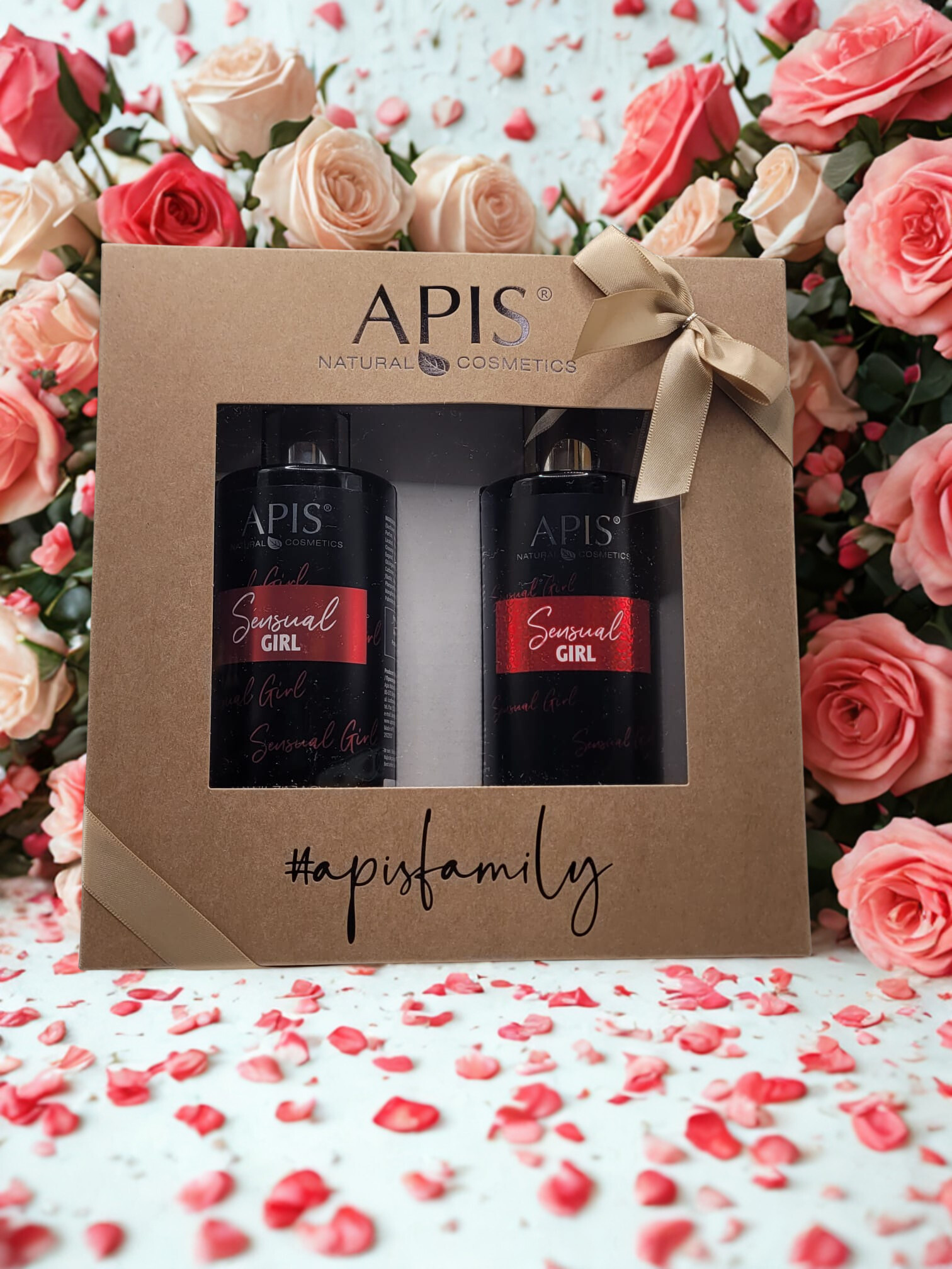 APIS natural cosmetics gift set with two bottles and a box against a floral background